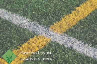 Artificial turf with white and yellow lines on a green field.