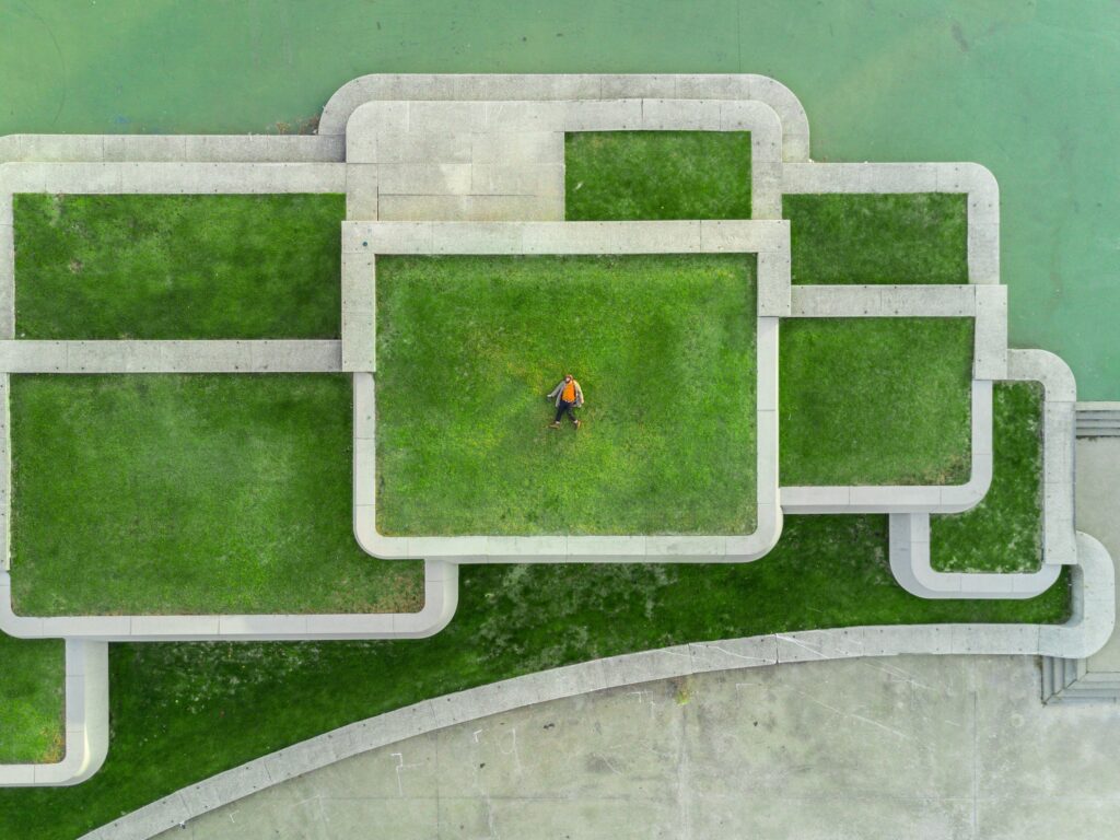 Aerial view of a landscaped area with artificial grass and concrete pathways.