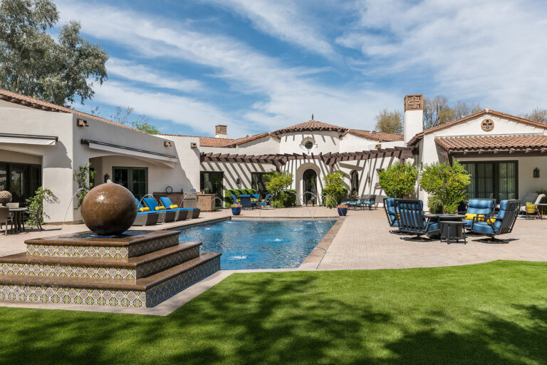 Beautiful backyard with artificial grass, pool, and outdoor seating.