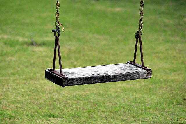 Swinging wooden swing on a lush green lawn in Arizona.