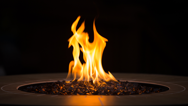 Fire pit with flames on artificial grass in backyard setting.