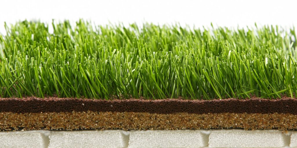 Close-up of lush artificial grass with layered infill for durability.