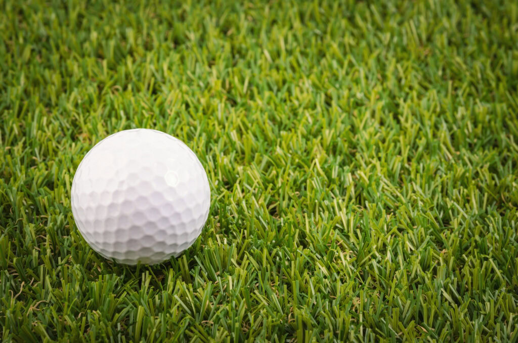 Golf ball on lush green putting green for practice and leisure.