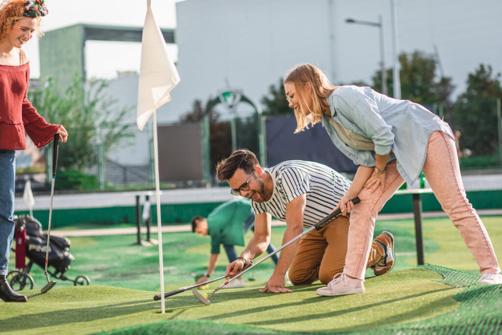 People enjoying a backyard putting green with friends and family.