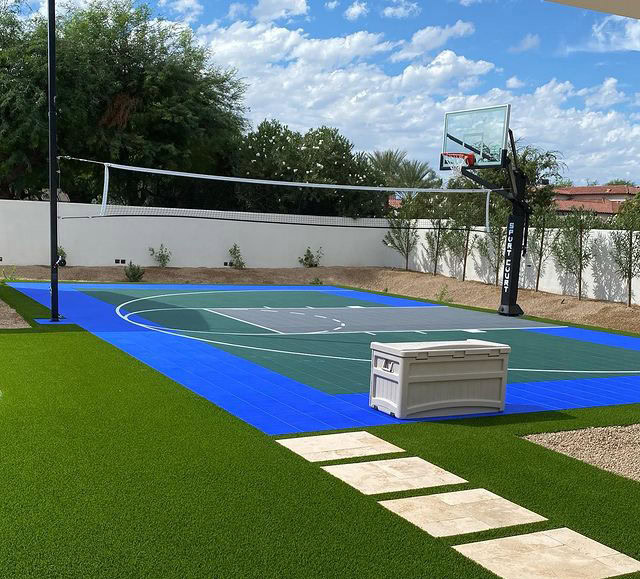 Luxury backyard basketball court with putting green and artificial turf.