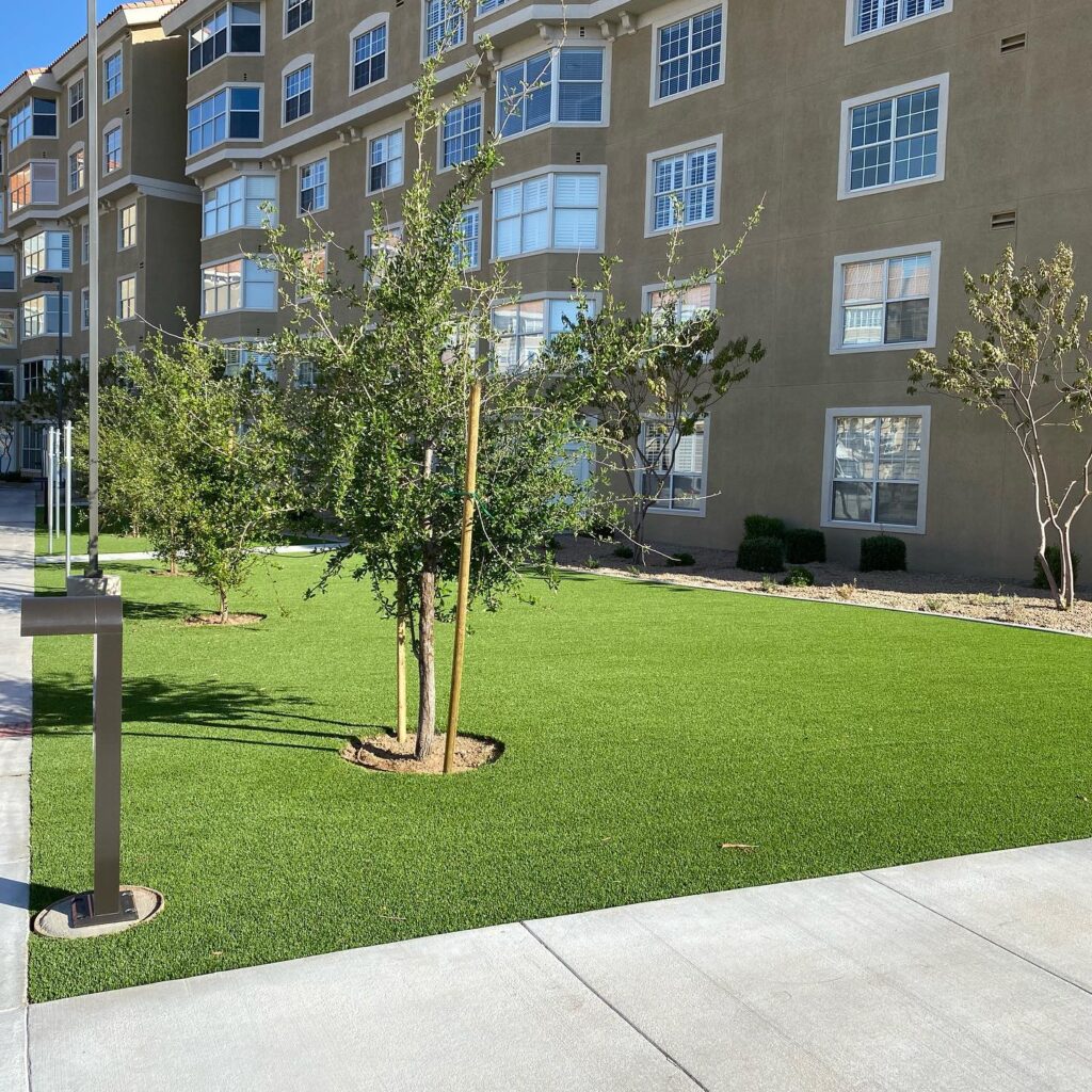 Beautiful landscaped lawn with trees and apartment building in Arizona.