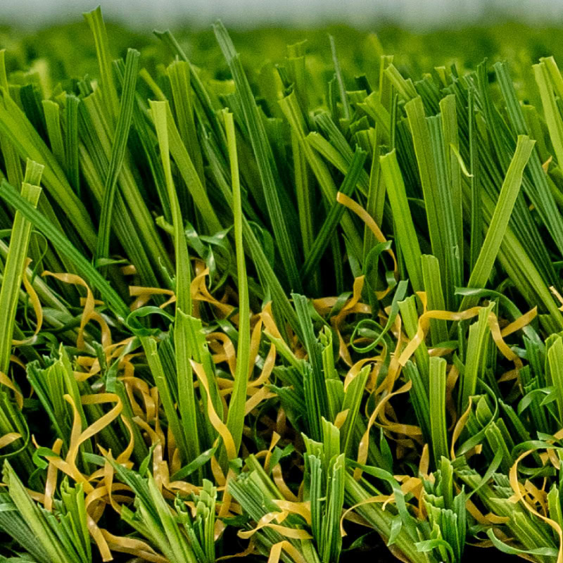 Close-up of lush green artificial turf with yellow infill fibers.