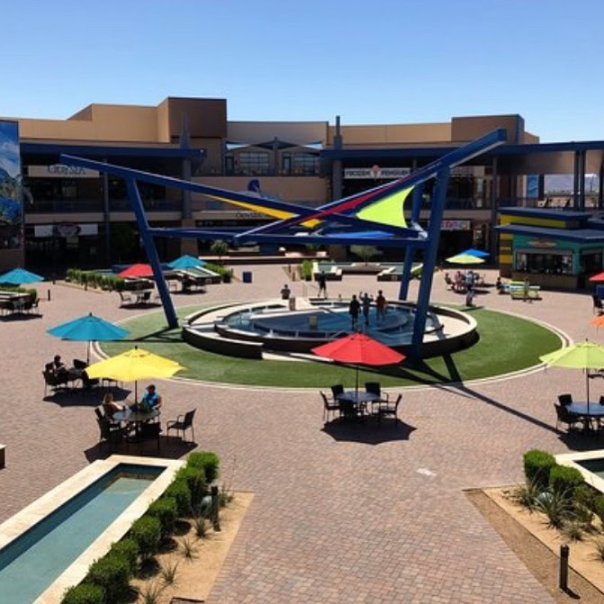 Modern outdoor space with putting green and seating area in shopping center.